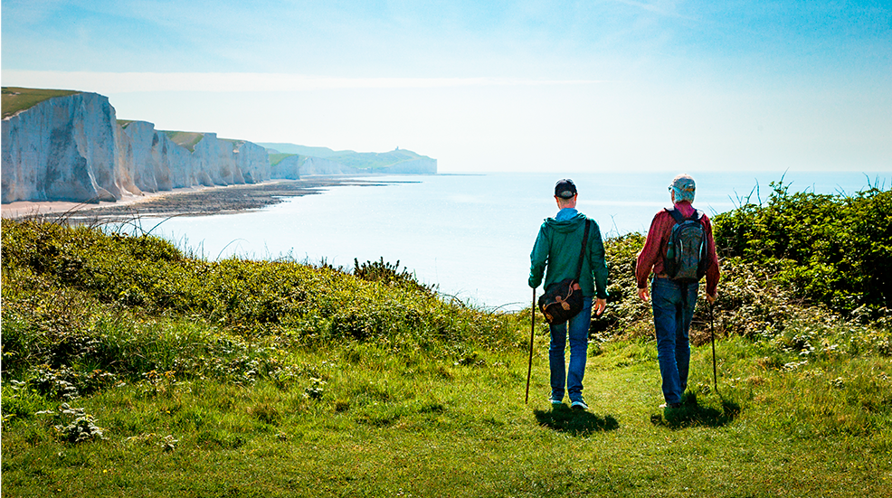 Two friends hiking together at Seven Sisters cliffs on the English south coast